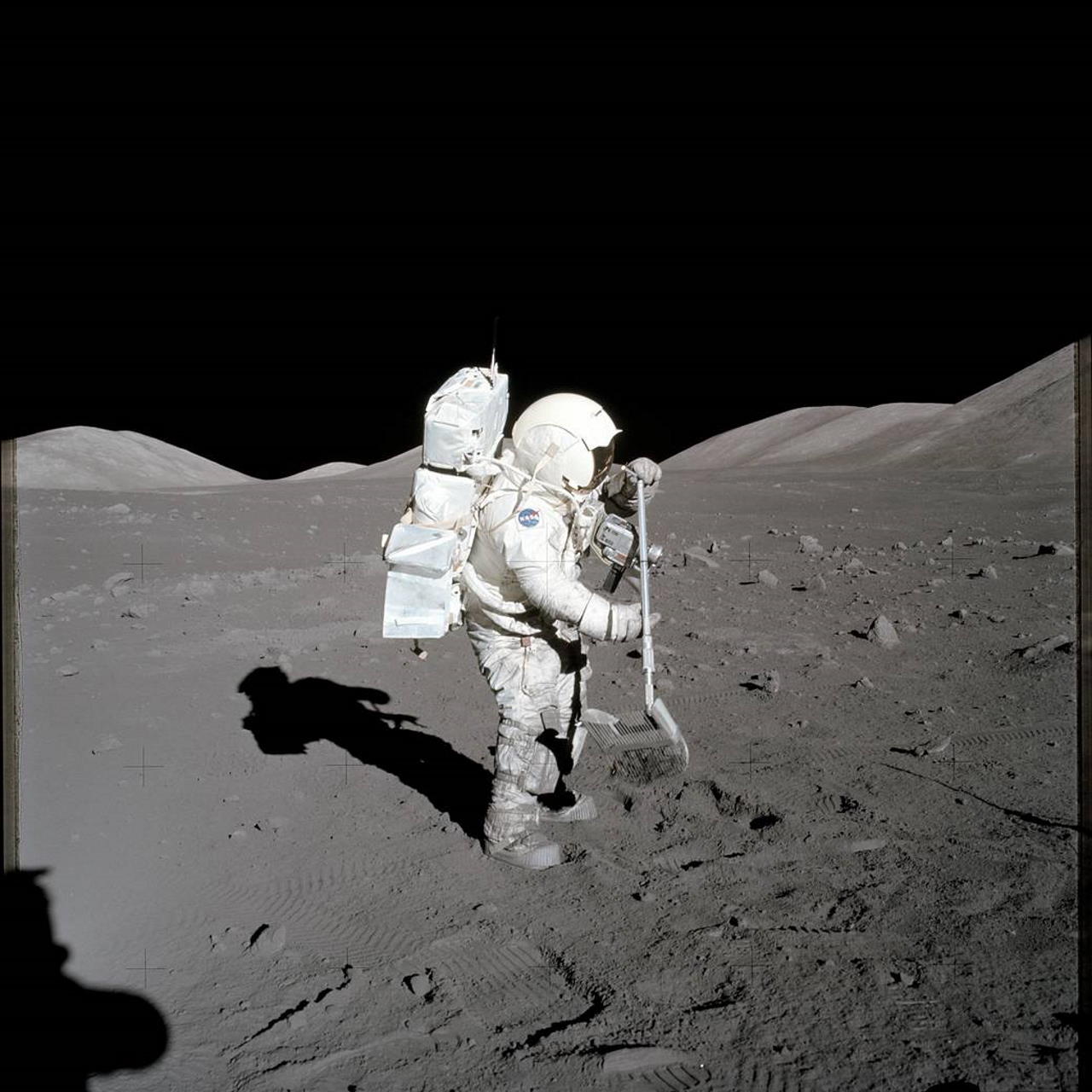 Гаррісон Шмітт збирає зразки за допомогою граблів. Автор фото  —  Юджин Сернан. Eugene Cernan / NASA